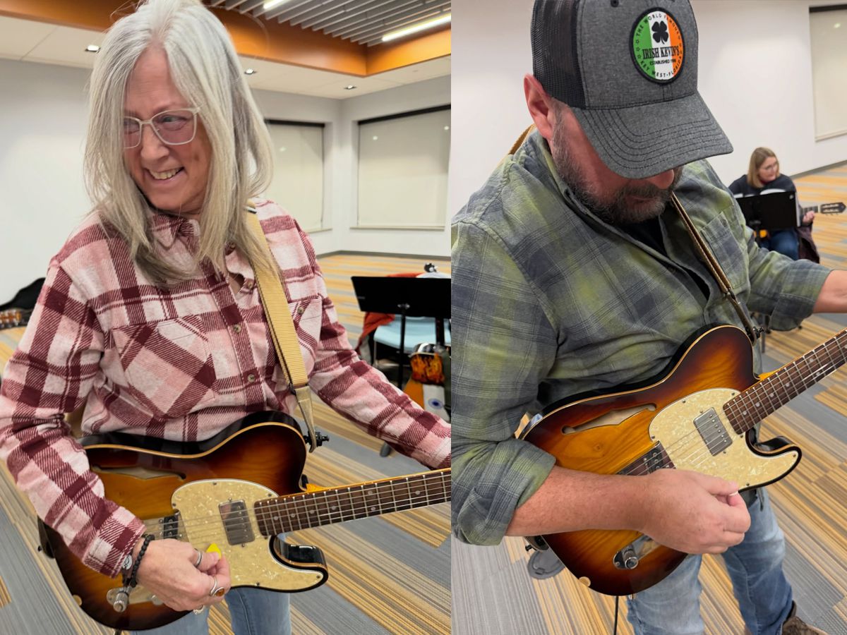 Two adult students playing electric guitars during a group guitar lesson